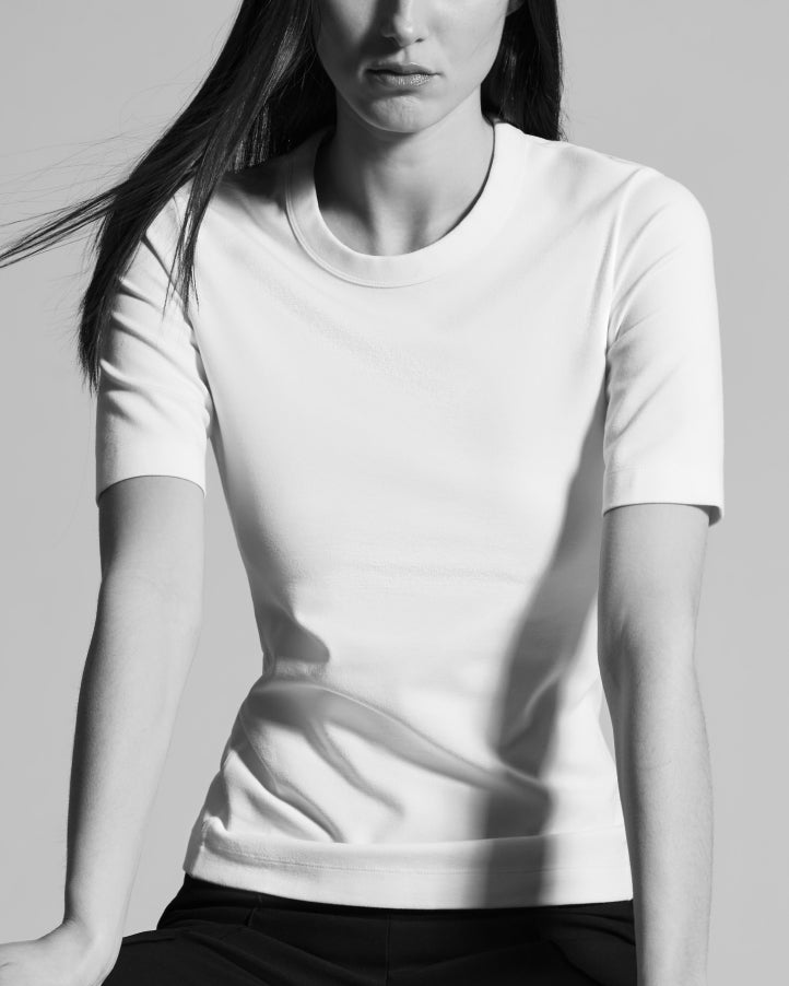 woman in white t-shirt with elongated short sleeves and thick collar detail